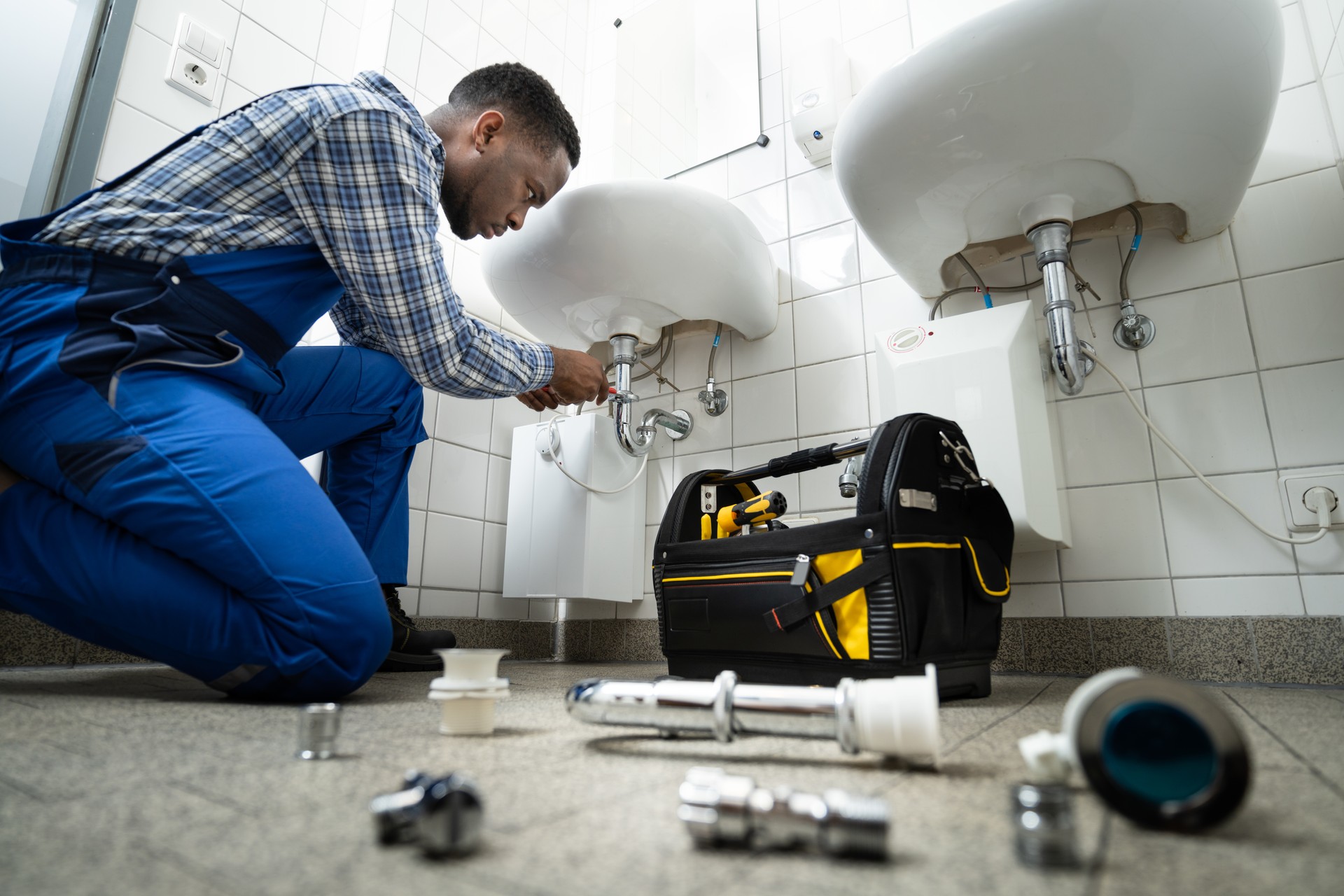 Plumber Fixing Pipe In Bathroom. Plumbing Maintenance